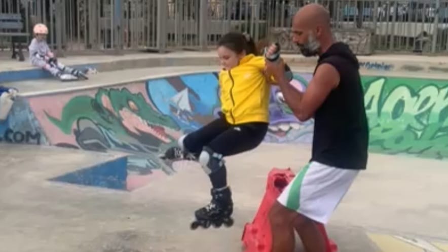Coach holding a young child's hand as they learn to skate
